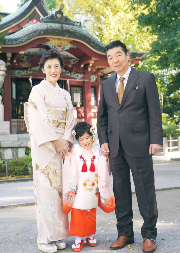 葛西神社の本殿前で祖父母様と手を繋ぐ女の子