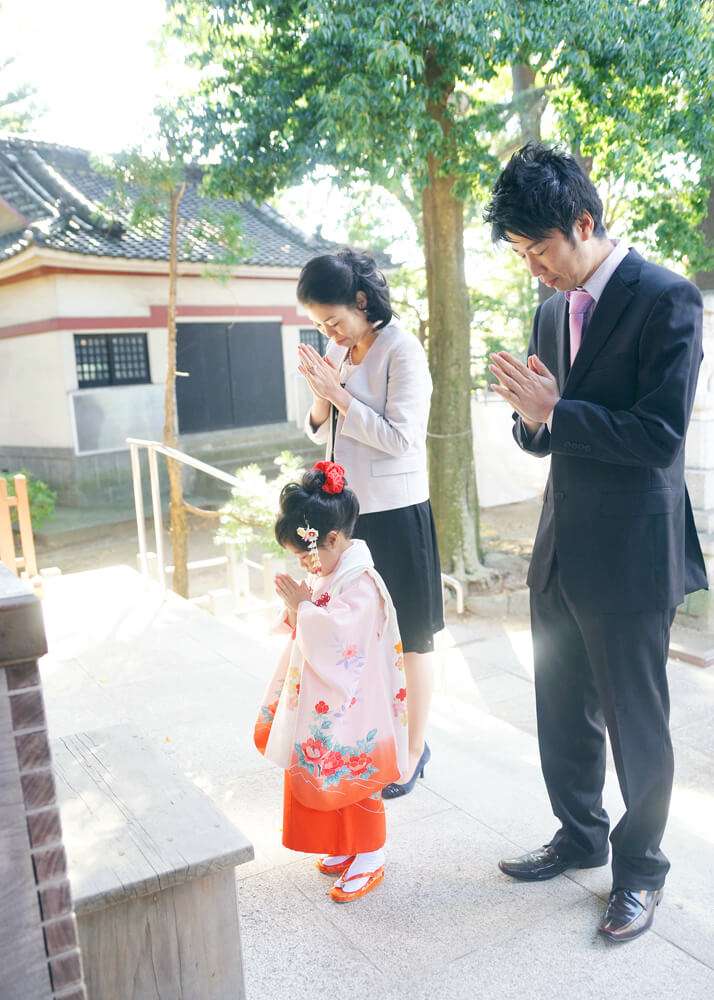 葛西神社の本殿前でお参りする家族