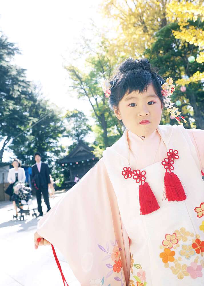 七五三の女の子を背後から見守るパパとママ