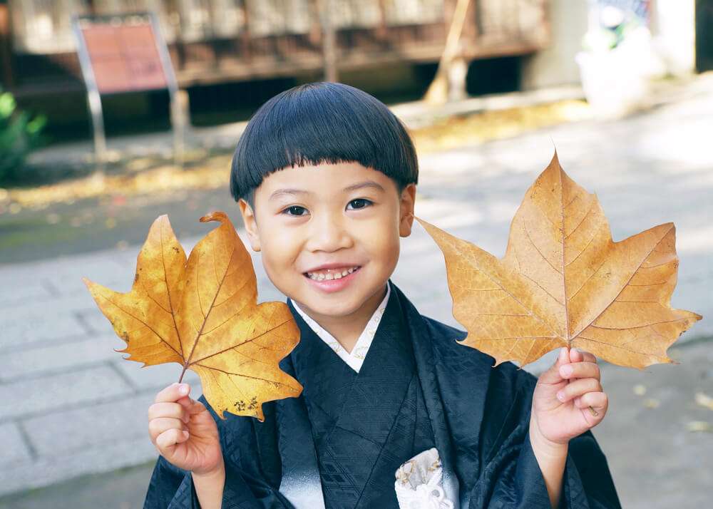 大きな葉っぱを見つけて喜ぶ男の子