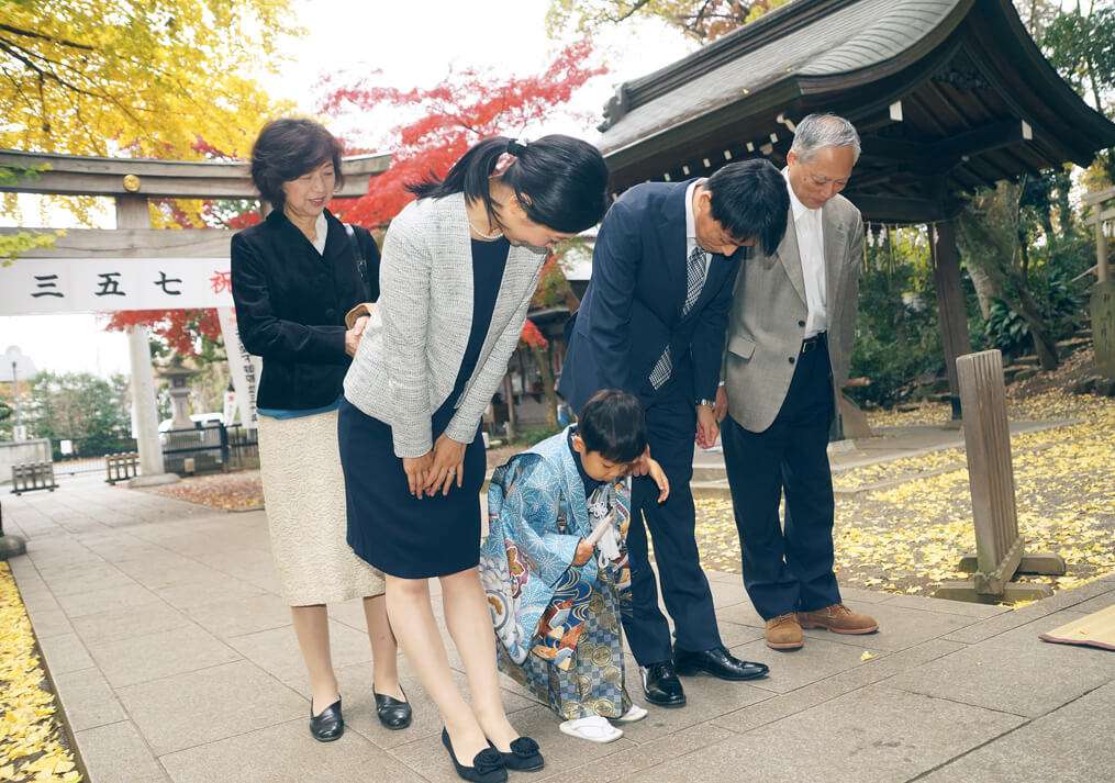 杵築大社の拝殿前でお参りをする家族