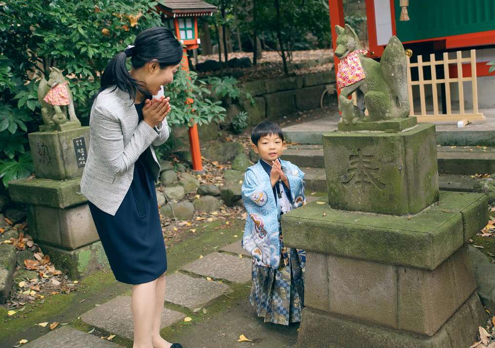 杵築大社の狐にお参りする男の子