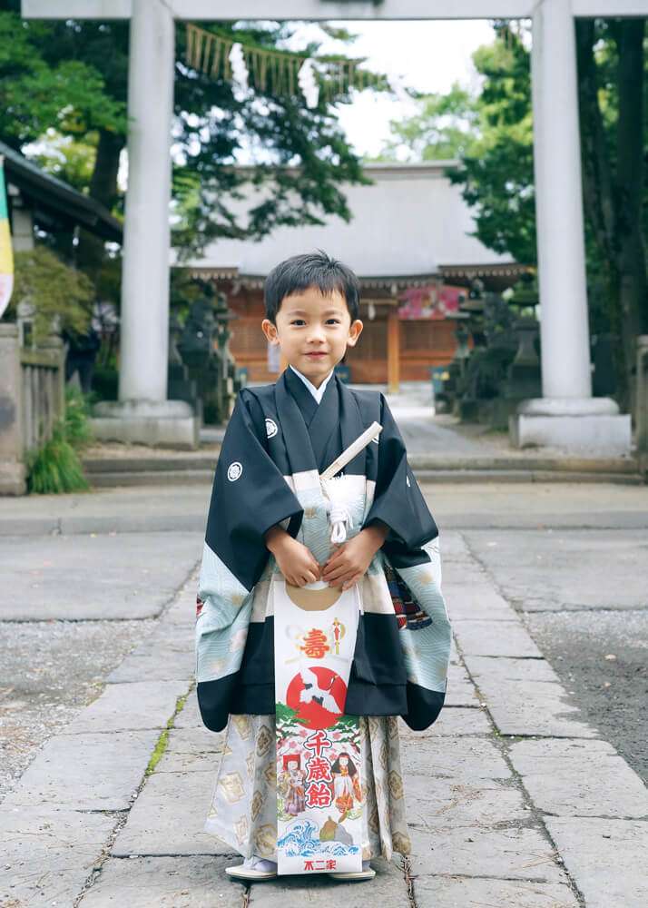 埼玉県蕨市和楽備神社の鳥居の前で千歳飴を持った男の子