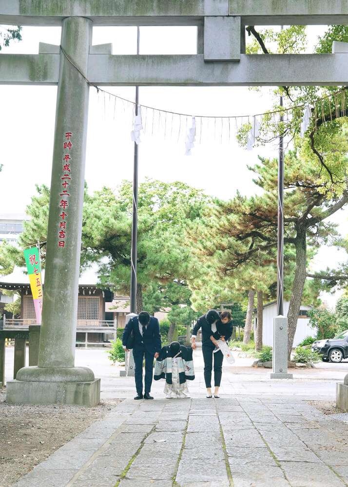 和楽備神社の鳥居の前でお辞儀をする家族