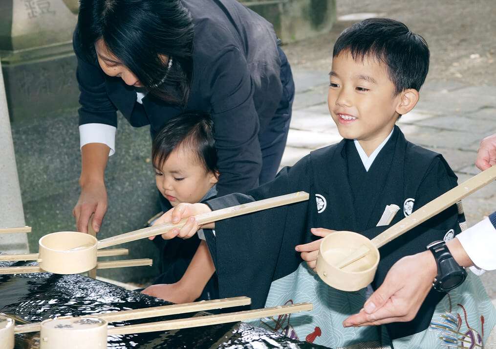 手水舎の桶を持つ5歳男の子