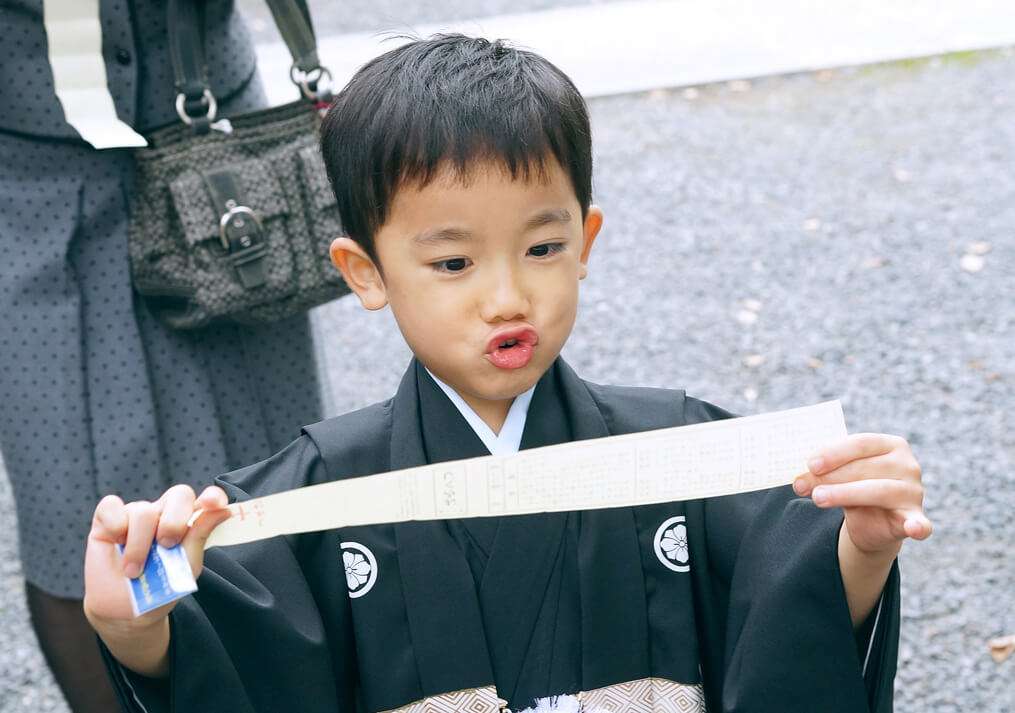 七五三のおみくじを喜ぶ5歳男の子