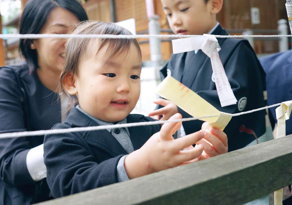 おみくじを縛る2歳男の子