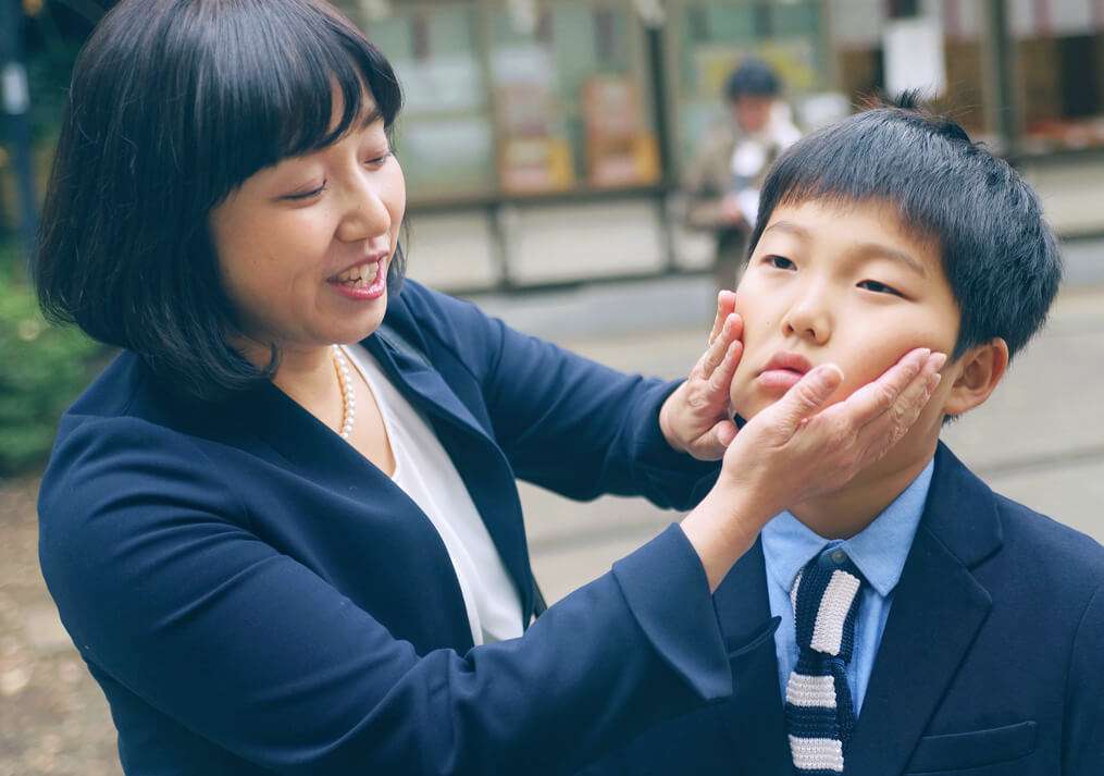 お兄ちゃんのほっぺを触るママ