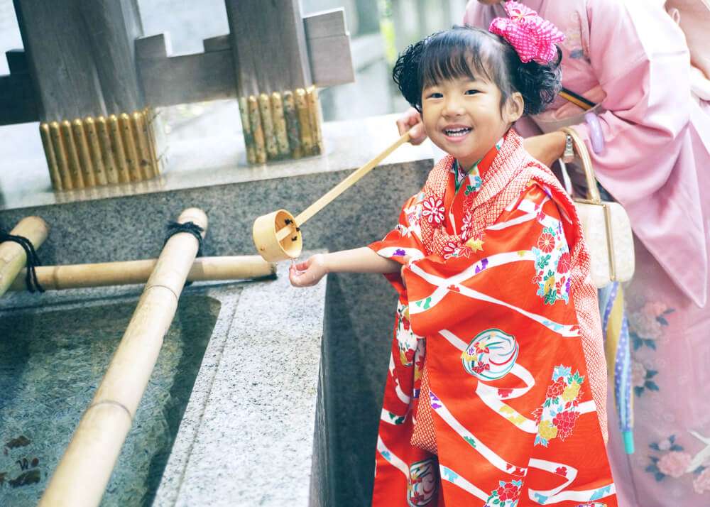 王子神社の手水舎で手を洗う妹