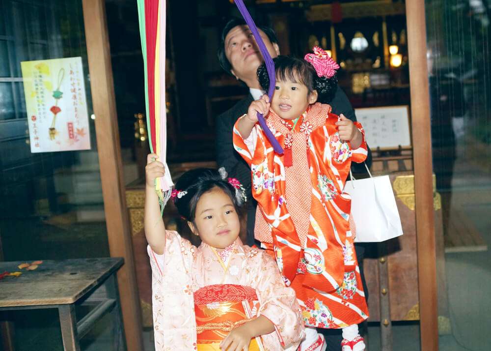 王子神社の鈴緒を握る姉妹