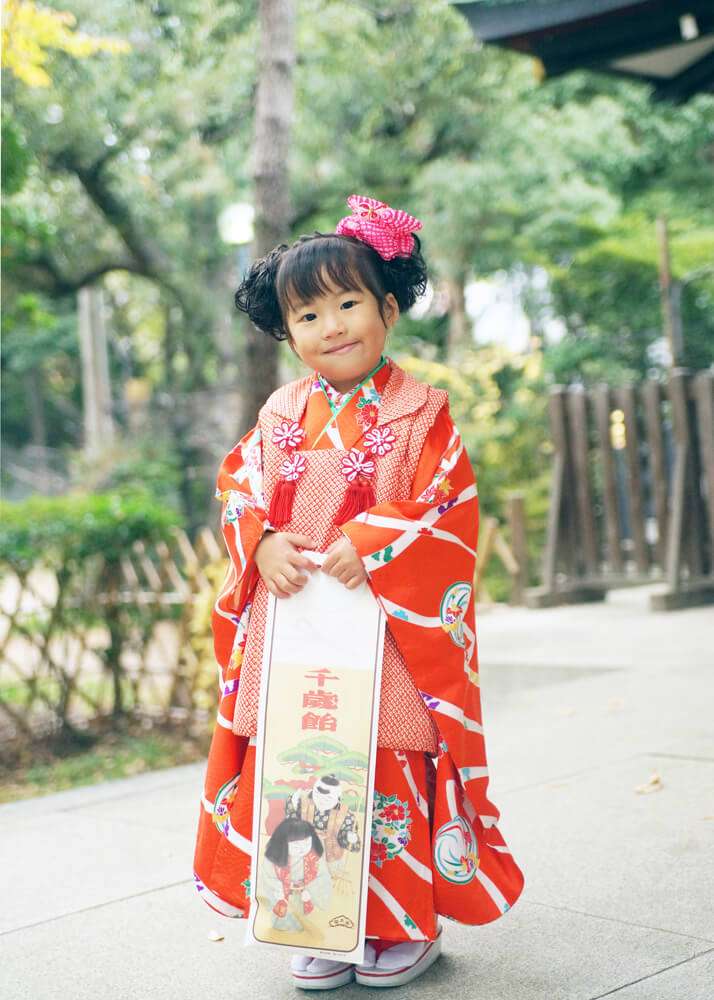 王子神社の拝殿前で千歳飴を持った妹