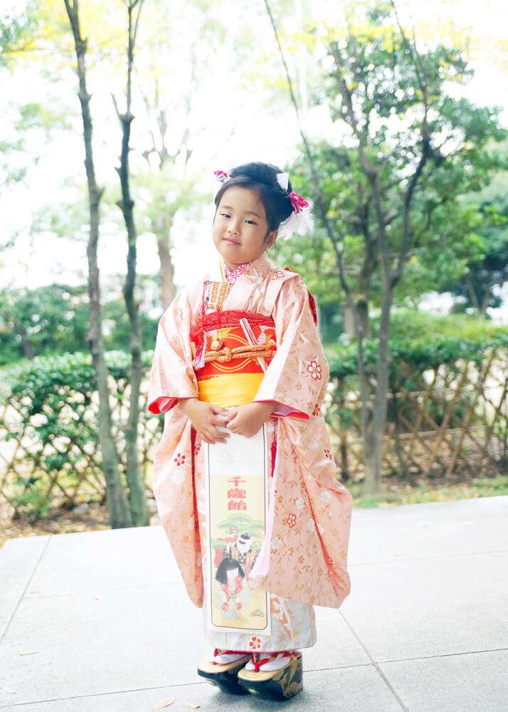 王子神社の拝殿前でぽっくりを履いた姉の写真