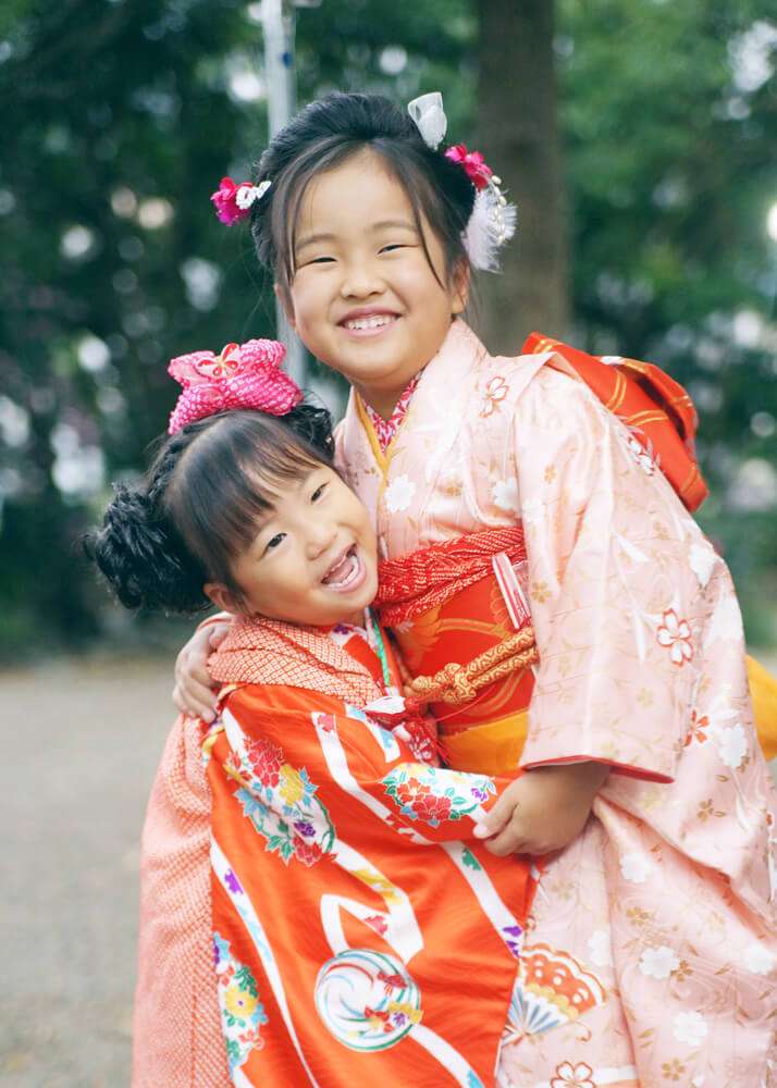 天満宮小金井神社の本殿前でじゃれあっている七五三の姉妹