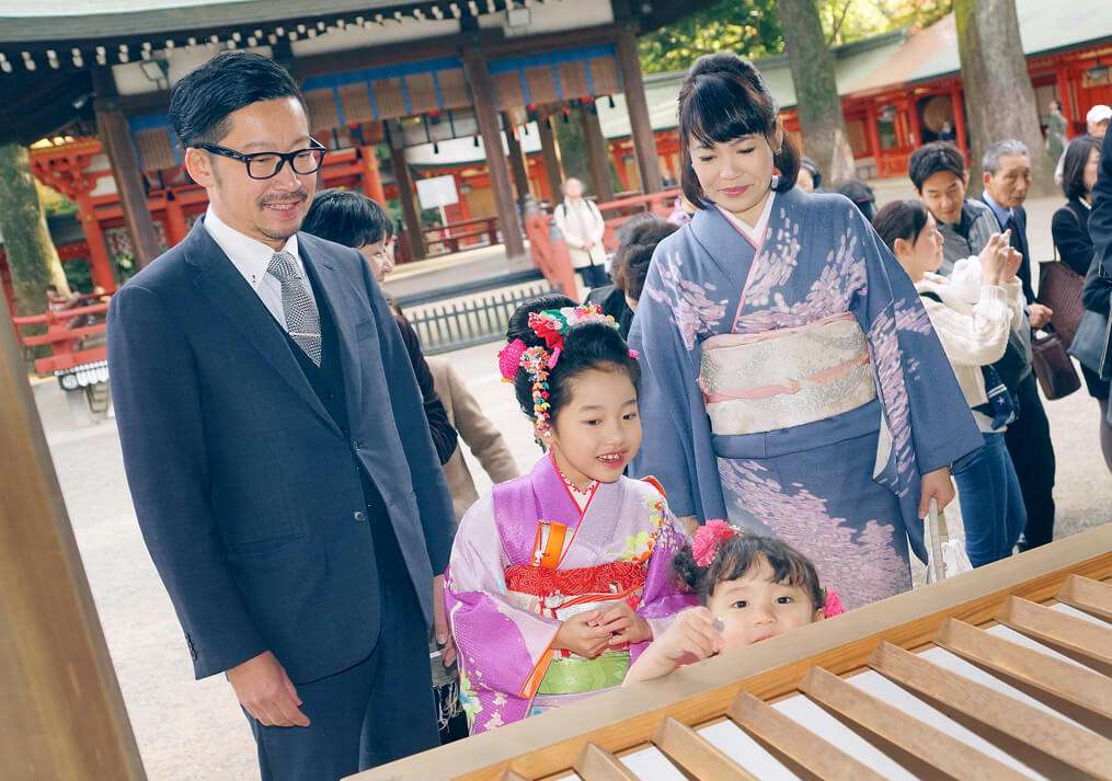 大宮氷川神社のお賽銭の前に立つ家族