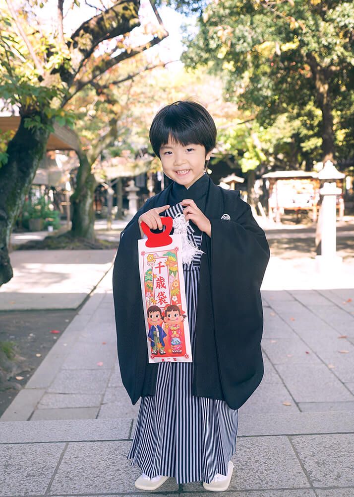 川口神社の本殿前でポーズをとる七五三の男の子