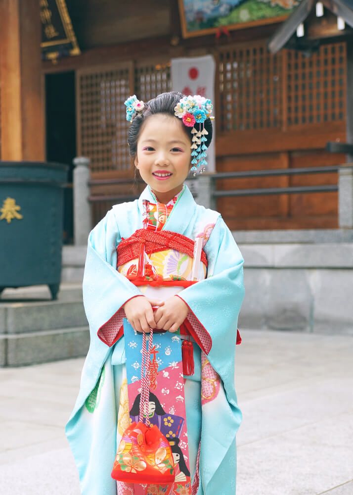 和羅備神社の本殿前で千歳飴を持った七五三の女の子