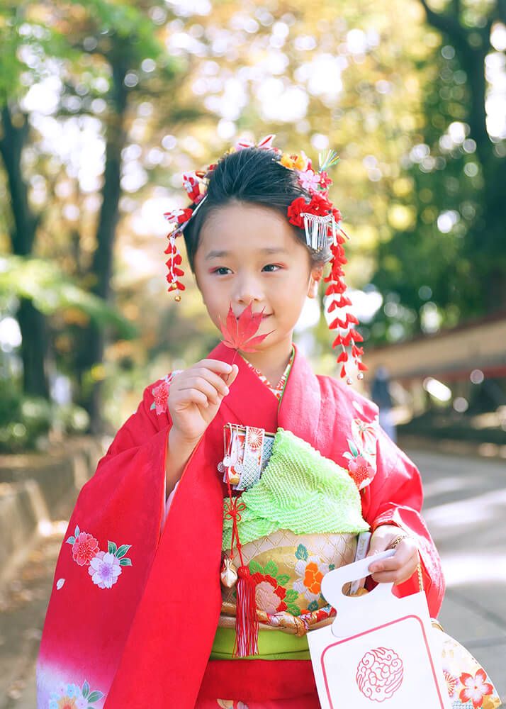 大宮氷川神社の参道でモミジを拾う七五三の女の子