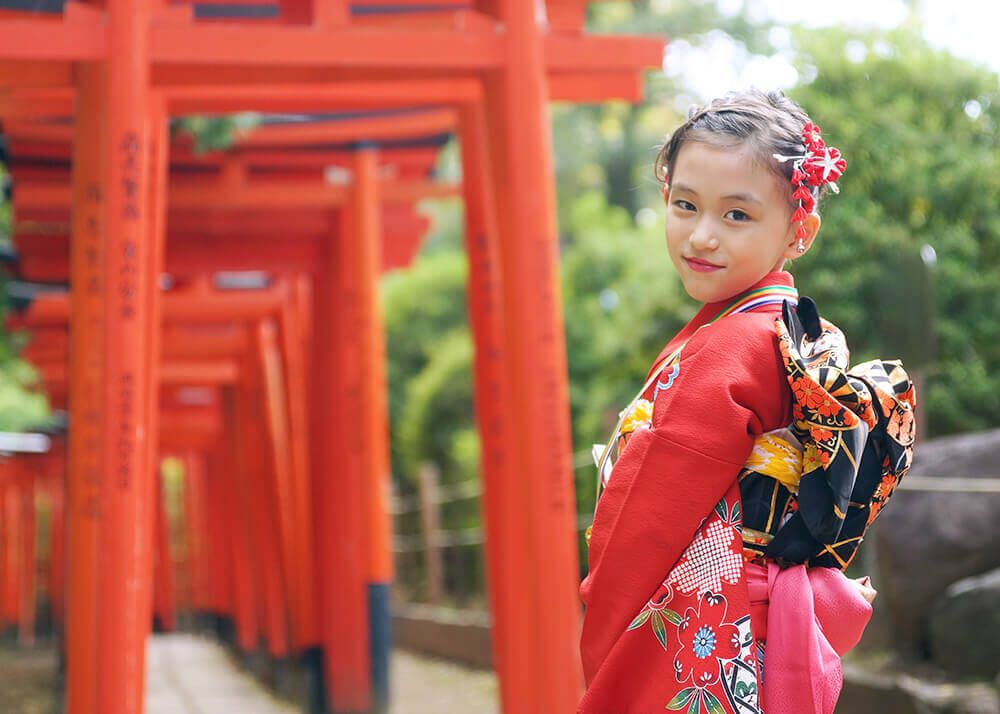 根津神社の千本鳥居の前でポーズをとる七五三の女の子