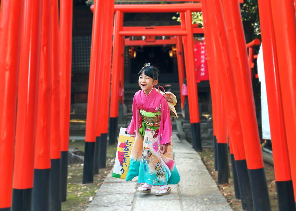 品川神社の千本鳥居の中でポーズをとる七五三の女の子