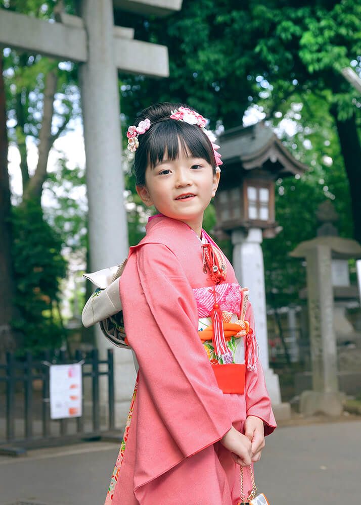 布多天神社の鳥居の前でポーズをとる七五三の女の子