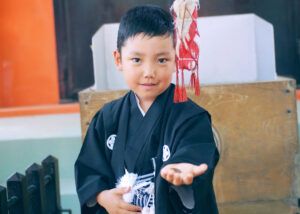 高幡不動の参道を走る七五三の男の子