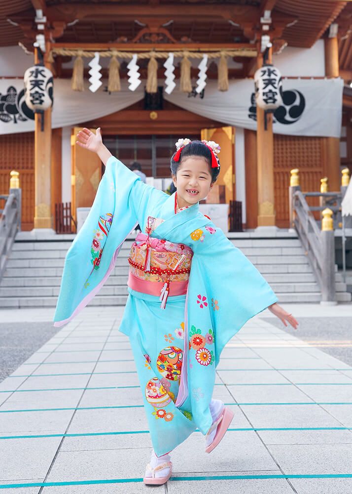 東京水天宮の本殿の前でポーズをとる七五三の女の子