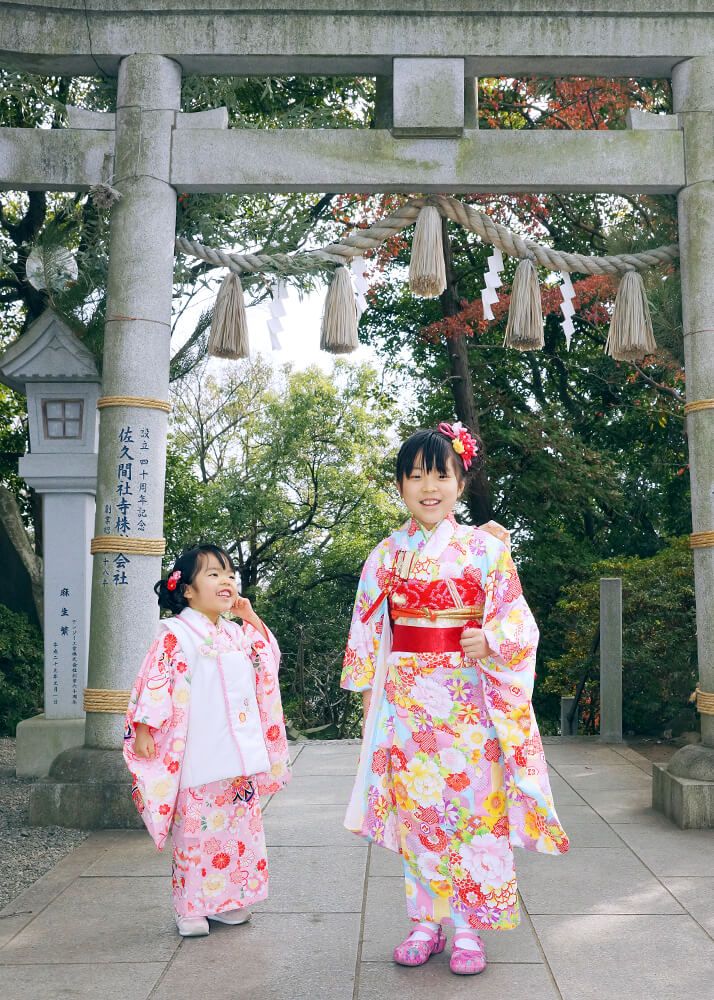 多摩川浅間神社の鳥居前でポーズをとる七五三の女の子