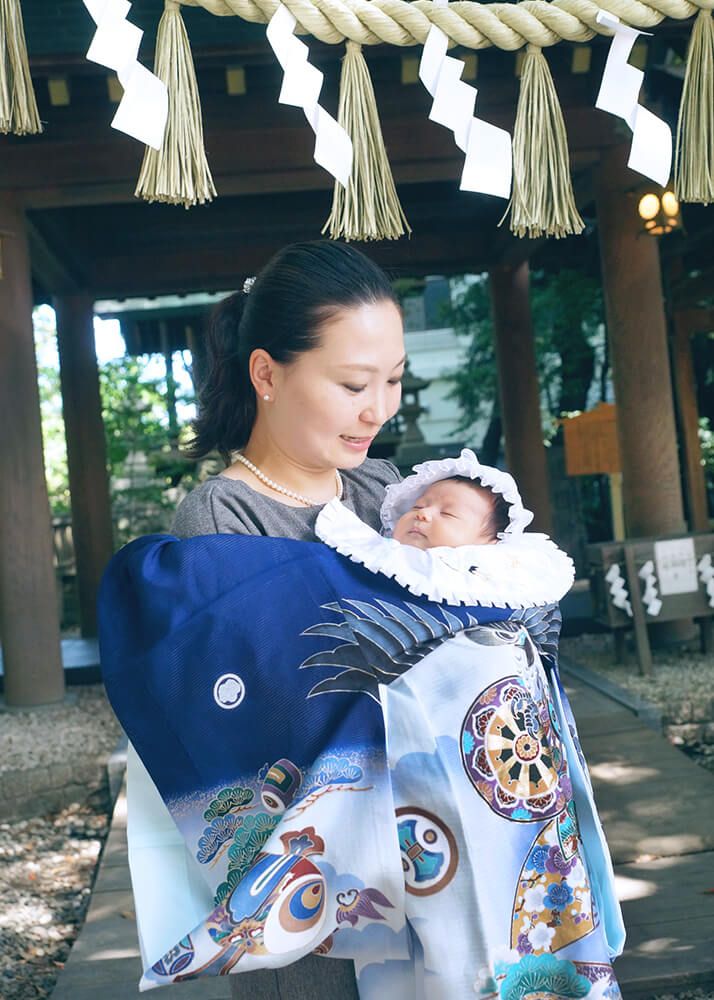 川越氷川神社でのお宮参りで青い祝い着を掛けたママ