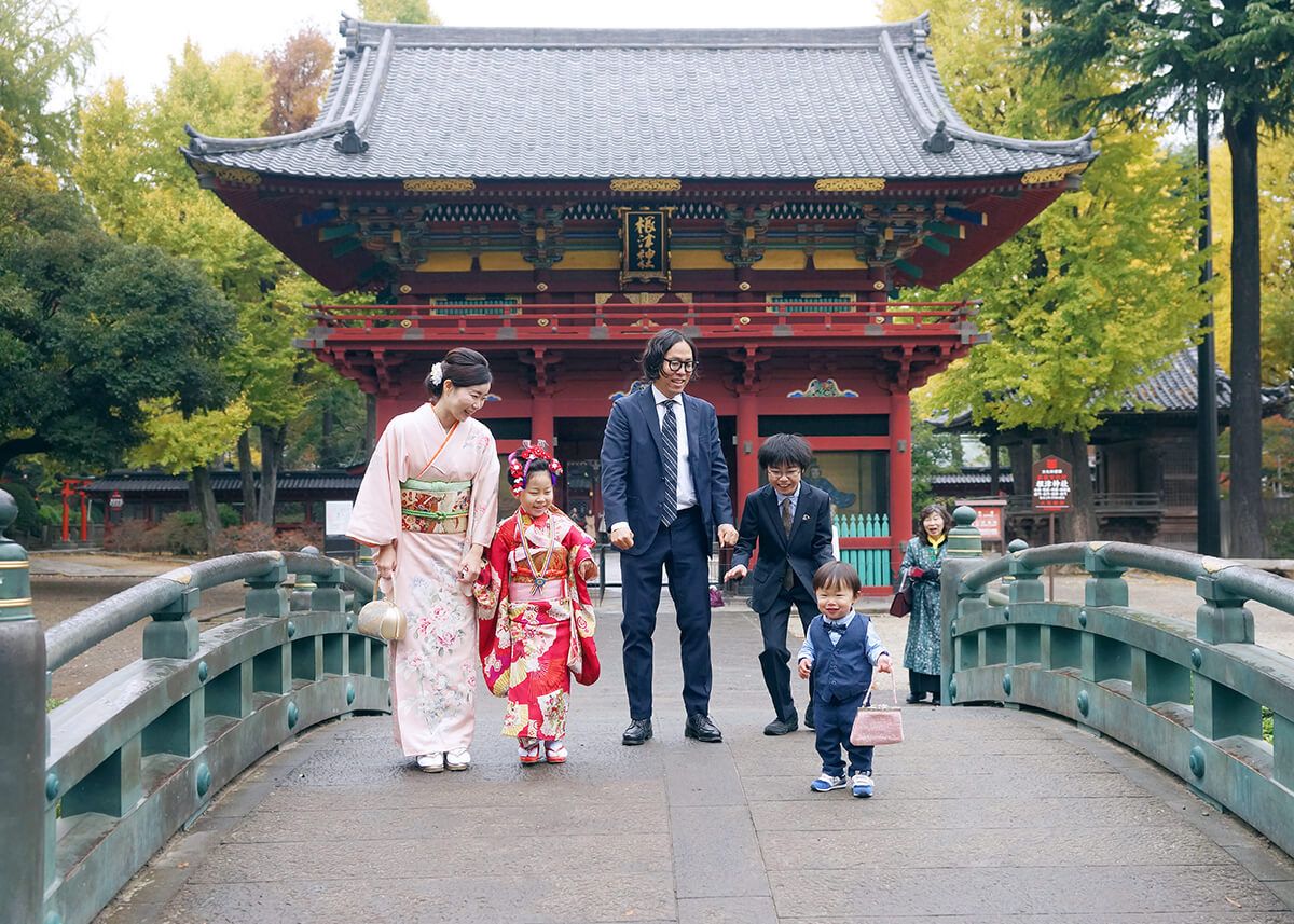 根津神社の青い橋の上で遊ぶ七五三の家族