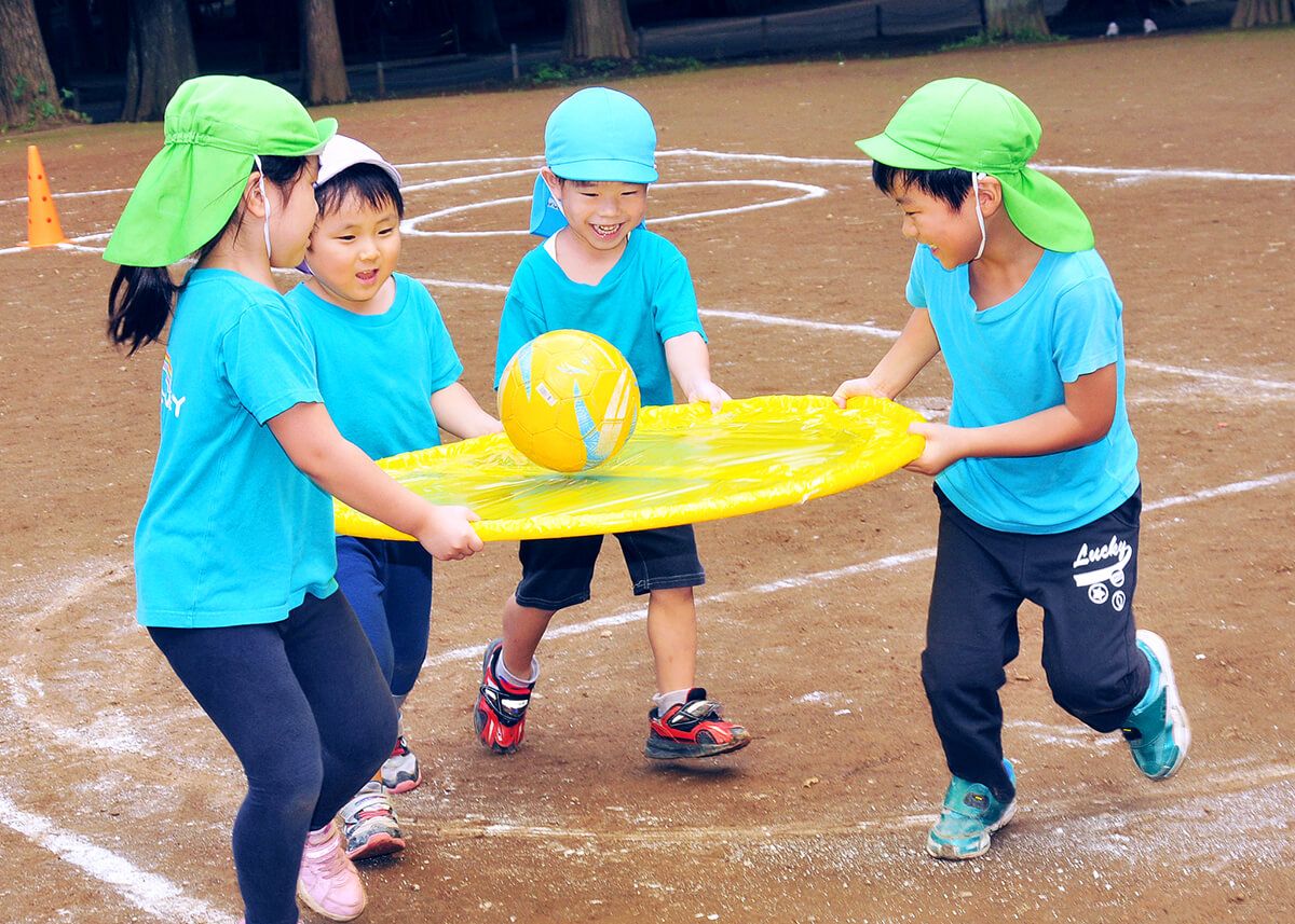 保育園の運動会で球を運ぶ男の子