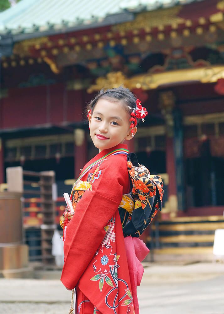 根津神社の本殿前でポーズをとる7歳女の子