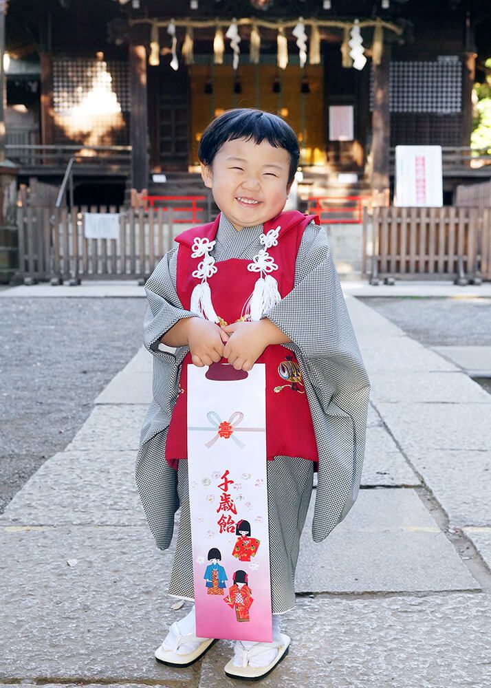 代々木八幡宮の本殿前で千歳飴を持った七五三の男の子