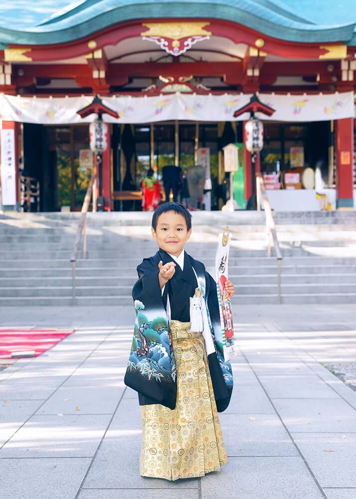 多摩川浅間神社の本殿前でポーズをとる七五三の男の子