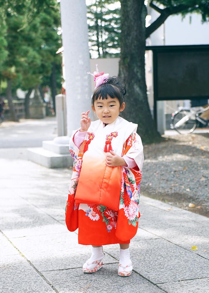 草加神社の参道でポーズをとる七五三の女の子