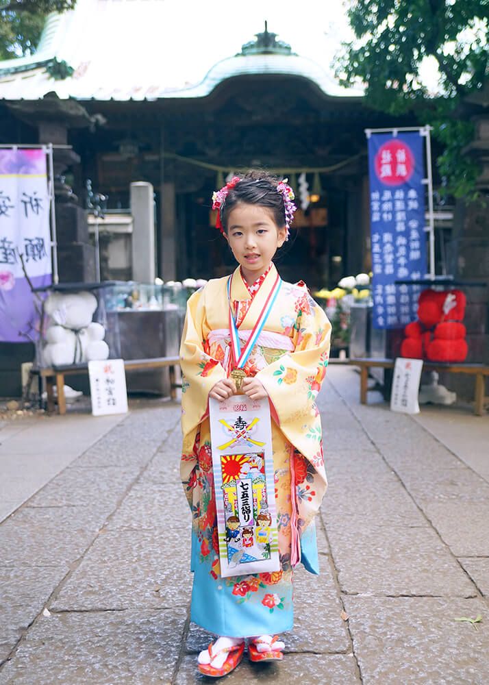 戸越八幡神社の本殿前で千歳飴を持った七五三の女の子