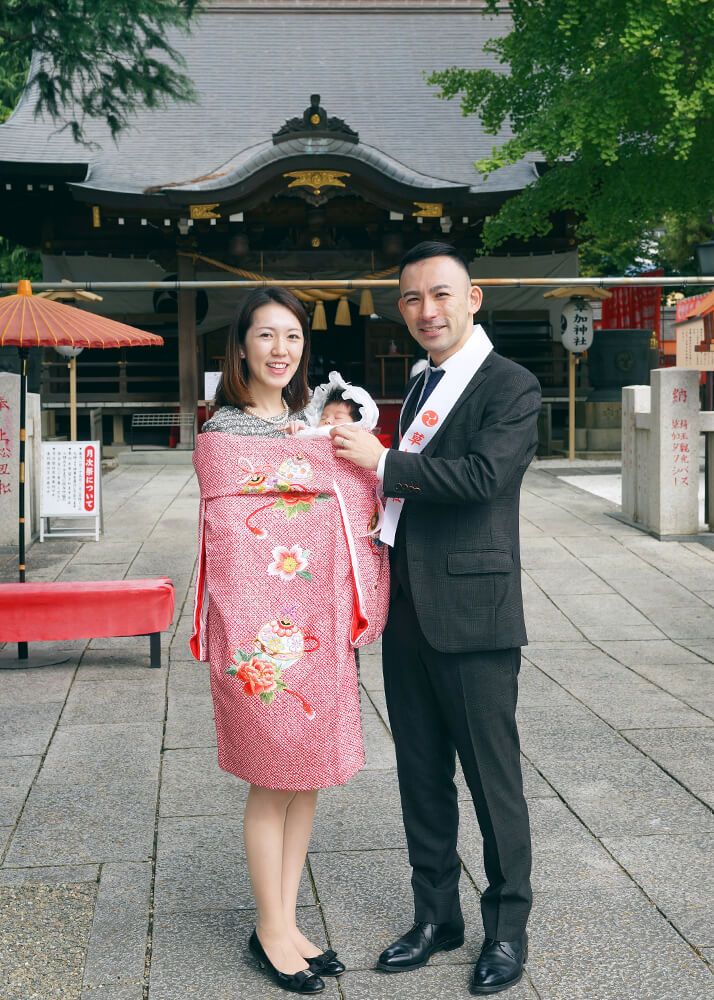 草加神社の参道でお宮参りの赤ちゃんを抱っこするママ