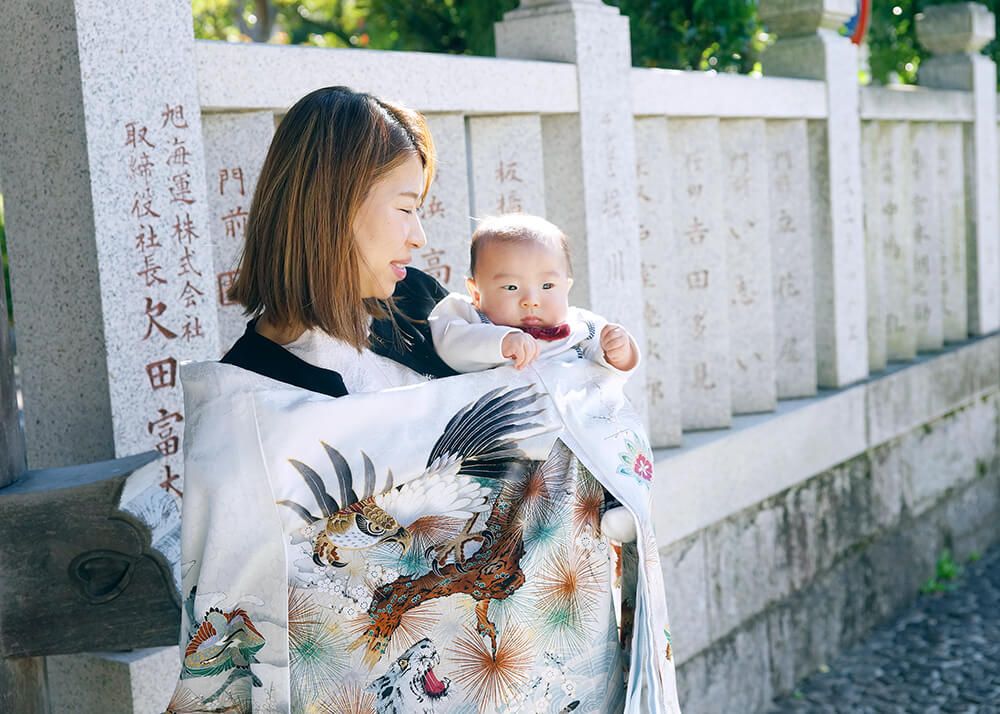 柴又帝釈天でのお宮参りで白い祝い着をかけたママ