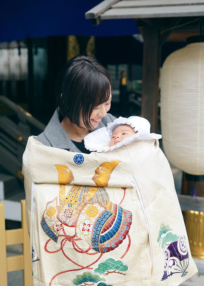 東京大神宮の本殿前で赤ちゃんを抱っこするママ