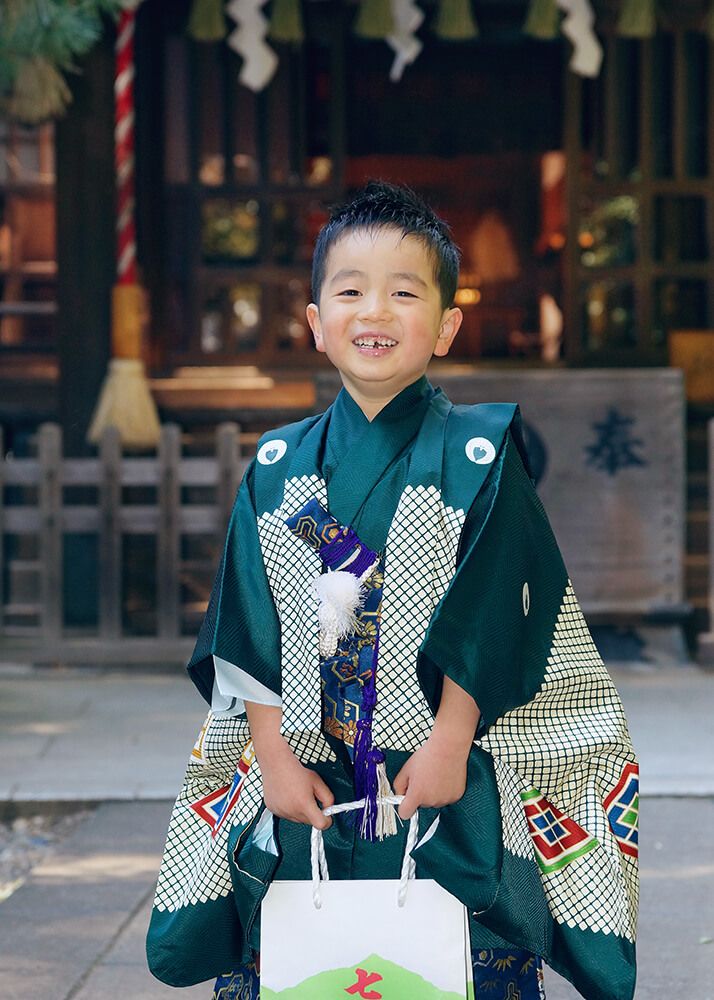 常盤台天祖神社の本殿前で千歳飴を持った七五三の男の子