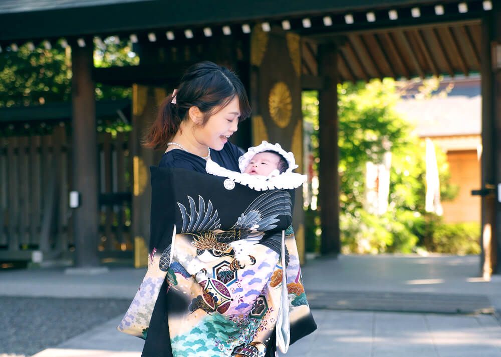 阿佐ヶ谷神明宮でのお宮参りで黒い祝い着を掛けたママ